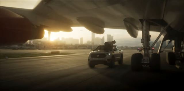 A pickup under an airliner on the runway. Still from official footage, Rockstar Games