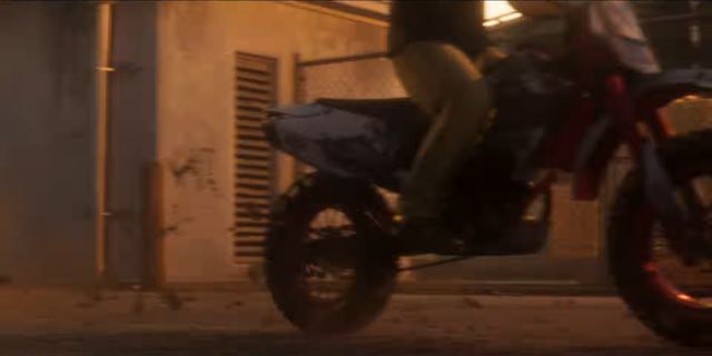 Dirt bike in an alley, helmet on. Still from official footage, Rockstar Games