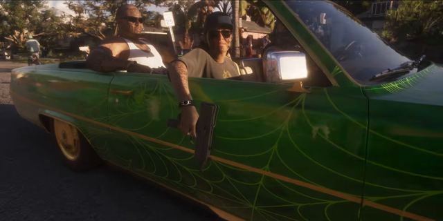 A green lowrider, pistol out. Still from official footage, Rockstar Games