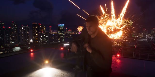 A rifle on a helipad, explosion behind. Still from official footage, Rockstar Games